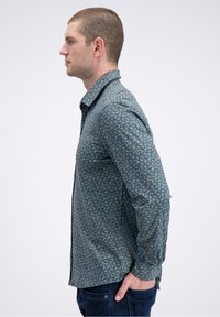Gestreept shirt met een teal-blauwe basis, voorzien van geometrische patronen in crème en marineblauw. Lange mouwen en een klassieke kraag, slim fit.