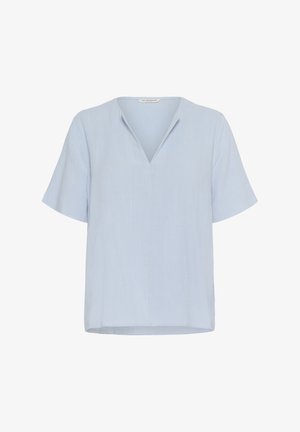 Világoskék, rövid ujjú blúz, V-kivágással, sima anyagból készült. Lazább szabású és egyenes szegélyű. Nincsenek minták vagy díszítések.