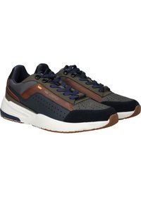 Herensneakers met een mix van marineblauwe, bruine en olijfgroene materialen, voorzien van geperforeerde details, textuuraccenten en een witte rubberen zool.