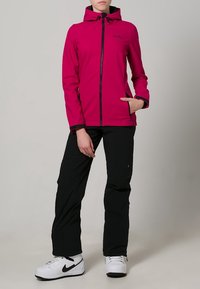 Fuksjowa kurtka z kapturem z czarnymi akcentami, z zapięciem na zamek i kieszenią. Połączona z czarnymi spodniami i białymi trampkami, na neutralnym tle.