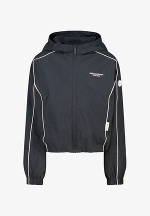 Musta vetoketjullinen huppari, jossa valkoiset reunukset hihoissa ja hartioilla, joustavat resorit hihoissa ja pieni valkoinen kirjailtu teksti rinnassa.