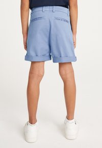 Hellblaue Shorts mit umgeschlagenem Saum, aus glattem Stoff gefertigt. Verfügt über Gesäßtaschen und ein Etikett mit der Aufschrift „BAKER BY TED BAKER“.