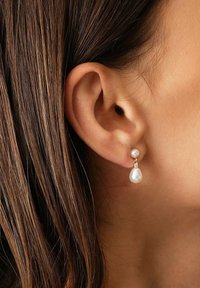 Perlohringe mit einer runden Oberperle und einem Tropfenperlen-Anhänger, akzentuiert mit einem kleinen Stück aus klarem Strass, auf einer vergoldeten Fassung.
