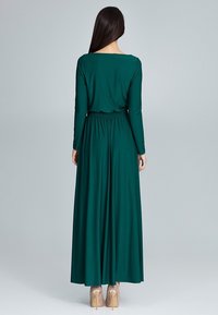 Dlouhá, přiléhavá šaty z měkké zelené látky. Mají dlouhé rukávy, nařasený pas a splývavou sukni. Vysoký výstřih a elegantní design.