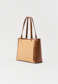 Borsa a tracolla in pelle marrone e paglia intrecciata con borchie dorate su un lato. Presenta due manici e una forma rettangolare strutturata.