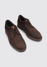 Zapatos de cuero marrón con un acabado suave, punta redonda, diseño de cordones y un cuello de tela marrón en contraste. Detalle de costura a lo largo de la suela.