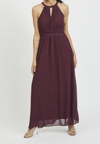 Lång burgundy klänning med halterneck, nyckelhål och rynkad spetsmidja; flödande chiffongmaterial med mjuk textur.