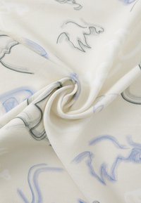 Mønstret stoff med abstrakte blå og svarte designs på en kremfarget bakgrunn, som fremhever en jevn tekstur og myk fall.