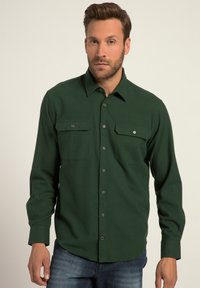 Camisa de botones verde hecha de un tejido texturizado, con dos bolsillos en el pecho y cierres a presión, mangas largas y un dobladillo recto.