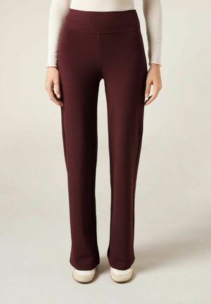 Maroon ribbed trousers with a wide waistband, straight leg design, and a smooth texture. Worn with light-colored shoes.