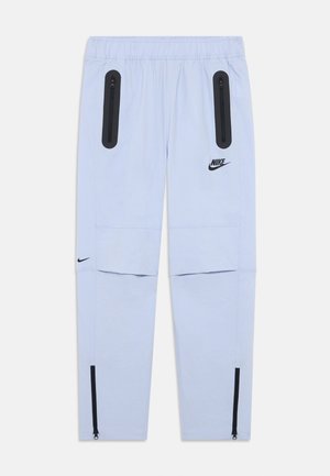 Pantalons de survêtement Nike bleu clair avec poches zippées noires sur les cuisses, logo Nike sur la cuisse droite et le mollet gauche, taille élastique et zips aux chevilles.
