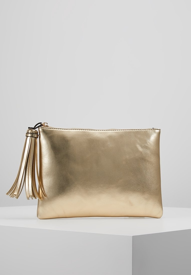 Kultainen metallinhohtoinen clutch-laukku, jossa on sileä pinta, vetoketjusuljenta ja pitkä, hapsuilla koristeltu koriste toisella sivulla.