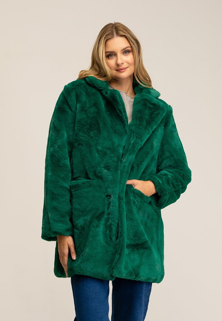 Cappotto in pelliccia sintetica verde con ampio colletto, tasche frontali e chiusura a bottoni. Texture morbida e silhouette oversize.
