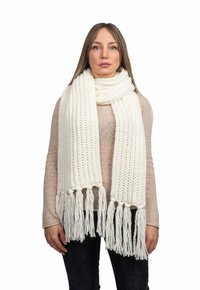 Sciarpa chunky bianca lavorata a maglia con estremità frangiate, realizzata in materiale morbido. Il motivo testurizzato presenta punti prominenti e si drappeggia in modo morbido.
