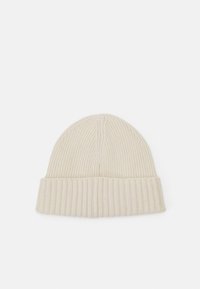 Cream-colored ribbed beanie knit from a soft material, featuring a folded cuff and a rounded top. Simple and functional design elements.