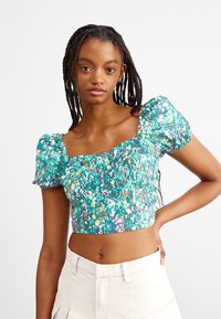 Zelený květinový crop top s puff rukávy, s obdélníkovým výstřihem a elastickým nařasením. Tkanina má texturovaný vzor s různobarevnými květy.