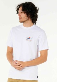 Hvid bomulds t-shirt med et lille farverigt grafisk motiv af en sol og palmetræer på brystet; korte ærmer og rund halsudskæring.