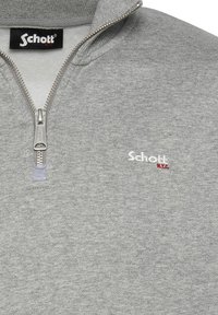 Sudadera con cremallera en tono gris, confeccionada en tejido suave, que presenta un alto cuello, cremallera plateada y un pequeño logo blanco y rojo de Schott en el pecho.