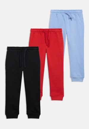 Três pares de calças de jogger para crianças em preto, vermelho e azul claro, com cintura elástica e cordões, dispostos em cima de um fundo branco.