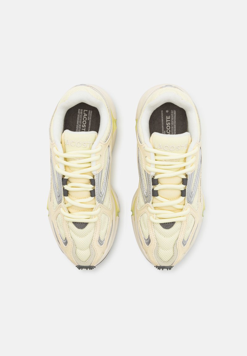 Sneakers Lacoste w jasnym żółtym kolorze z siateczki i skórzanymi detalami, szarymi akcentami i gumową podeszwą. Posiadają teksturowane sznurowadła i logo.