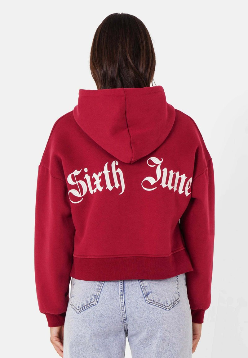 Felpa borgogna tagliata, realizzata in cotone, con la scritta gotica bianca "Sixth June" stampata sul retro. Tessuto morbido, cappuccio con cordino e polsini a costine.