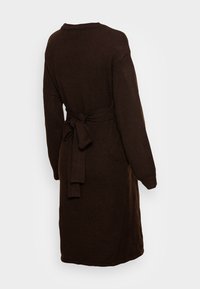 Brun stickad klänning med långa ärmar, ett bälte i midjan och en mjuk textur, med rundad hals och medellång design.