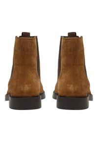 Bottines en suede marron avec des panneaux élastiques noirs sur les côtés, bout rond et languettes à l'arrière. Semelles noires plates et détails cousus.