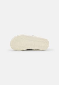 White flexible shoe sole with a textured pattern and subtle wave lines; smooth finish and rounded edges for comfort and stability.