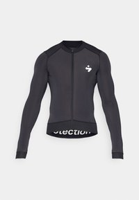Maillot de cyclisme à manches longues, noir, avec une fermeture éclair à l'avant, un col rond, un logo sur la poitrine et des détails en maille au niveau de l'ourlet.