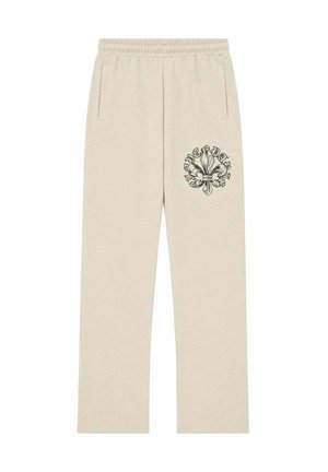 Pantalones deportivos beige con cintura elástica, bolsillos laterales y un emblema negro de flor de lis en el muslo derecho.