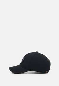 Casquette de baseball noire avec une visière incurvée, fabriquée en coton, dotée d'une étiquette brodée et d'un petit accent jaune sur le côté.