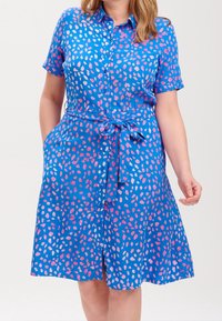 Abito a maniche corte con bottoni in tessuto blu con un motivo astratto rosa e bianco, dotato di vita con cintura e tasche laterali.