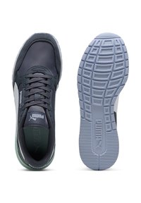 Sapatilha Puma cinza escuro e branca vista de cima com atacadores e sola com padrão de piso visível, exibindo o logótipo da Puma na lateral e na sola.