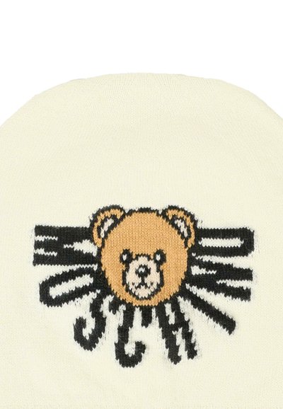 Beanie lavorato a maglia di colore crema con una grafica di un orso beige e accenti stilizzati neri. Texture morbida, forma arrotondata con una vestibilità aderente.