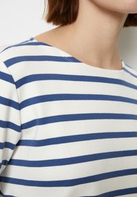 Gestreiftes Oberteil in Weiß und Marineblau, mit rundem Halsausschnitt und weichem Stricktextur. Sichtbare Details umfassen gleichmäßige horizontale Streifen.