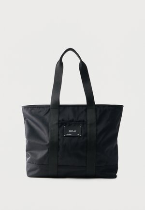 Black tote bag with two shoulder straps and a front pocket labeled "REPLAY" on a plain light background.