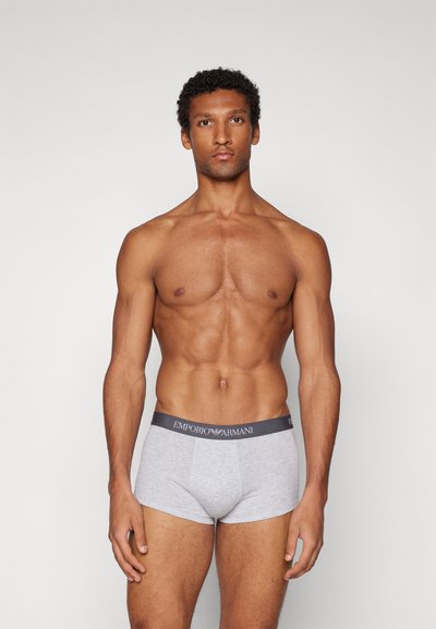 Šedé bavlněné boxerkové trenýrky s tmavým páskem s logem "Emporio Armani". Střih je těsný, s minimalistickým designem.