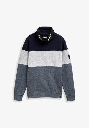 Plokkvärviline sviiter tumesinises, hallis ja heles hallis värvitoonis. Omab kaelust nuppudega ja ribatud varrukaotsasid. Pehme, tekstuuriga kangas.