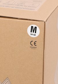 Brun pappkartong med en vit rund etikett som visar bokstaven "M" och storleksintervallet "54-58", samt CE-certifieringstexten under.