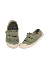 Zapatos de lona verdes con dos correas de velcro, puntera de goma color crema y suela texturizada. Presentan una marca en naranja en el lateral.