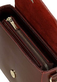 Borsa a mano in pelle borgogna con esterno liscio, hardware dorato e scomparto interno con zip foderato in tessuto. Chiusura a scatto magnetico.