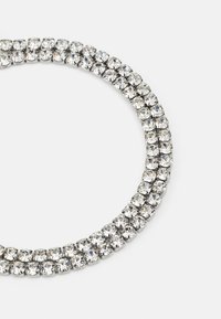 Rhinestone necklace featuring round, clear crystals set in silver-tone metal. Double-row design with a smooth, reflective finish.