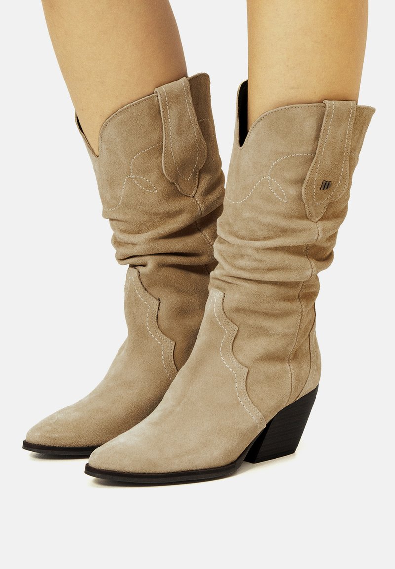 Beige Wildleder-Cowboystiefel mit lässigem Design, spitz zulaufender Zehenpartie und westernmäßigen Stickereien; verfügen über einen schwarzen Absatz und ein dekoratives Oberteil.