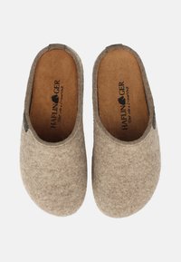 Brown felt slippers with a soft texture, rounded toe, and low back. Featuring a cork insole and a small logo tag on the side.