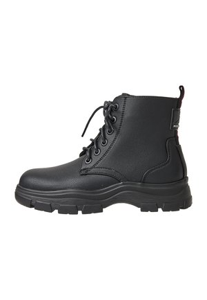 Black leather lace-up combat boot with thick rubber sole and pull tab at the back, shown in right side profile on white background.