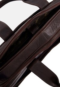 Mørkebrunt læder arbejdstaske med to lynlåslommer og robuste håndtag, delvist åben og viser det brandede indvendige foret.