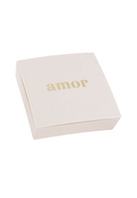Scatola quadrata di color rosa chiaro con angoli arrotondati, con la parola "amor" in lettere dorate sulla parte superiore. Superficie liscia e design minimalista.