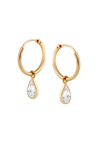 Złote kolczyki w formie kółek, ozdobione kroplowymi przezroczystymi kryształami zawieszonymi w dolnej części każdego kółka.