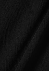 Schwarzer gerippter Stoff, glatte Textur mit dünnen, gleichmäßigen Linien. Das Material zeigt beim Lichtschein einen leichten Glanz. Weich und flexibel.