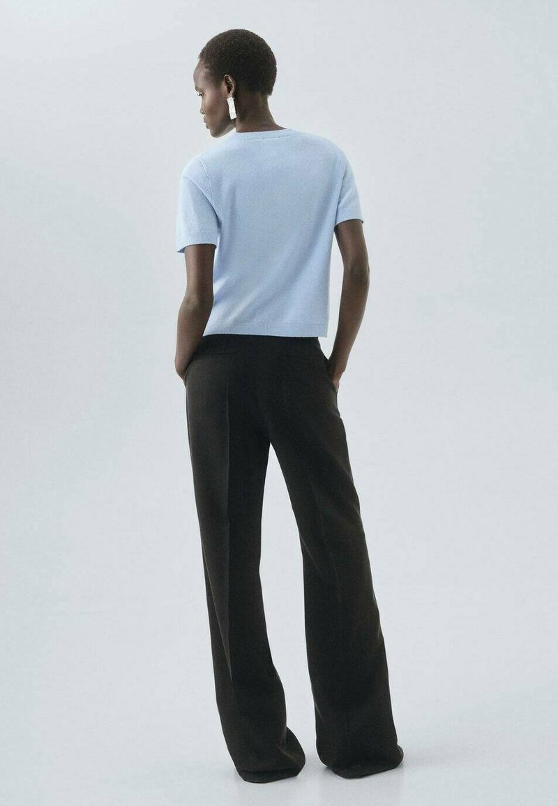 Bluet deschis, bluză cu mâneci scurte și guler rotund, asortată cu pantaloni largi negri. Textură moale, design minimalist, fără modele proeminente.